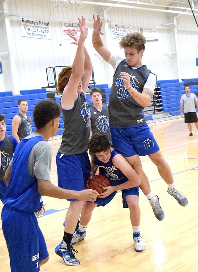 Photo by Mike Eckels Decatur&#8217;s Levi Newman (center) fights his way out of a pair of Hornet blockers during the Bulldog-Hornet scrimmage game which was part of the Colcord Summer Basketball League in the gym at Colcord High School on June 6.