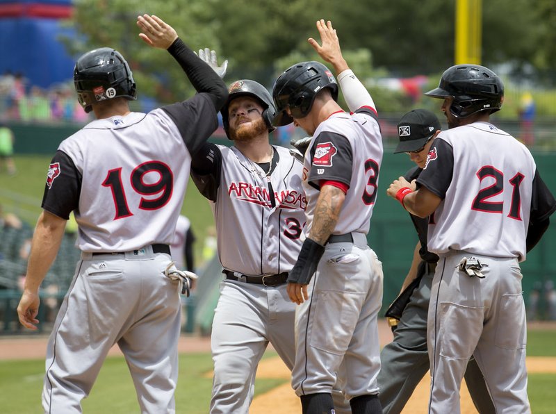 Arkansas Travelers Dario Pizzano (from left), Tyler Marlette, Ian Miller and Joey Wong celebrate following Marlette’s grand slam in the fourth inning Tuesday against the Northwest Arkansas Naturals at Arvest Ballpark in Springdale.