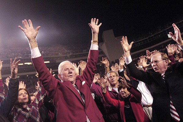  In this Nov. 3, 2007, file photo, former Arkansas coach and athletic director Frank Broyles, left, and school Chancellor John White, right, lead the school's cheer on the field at Reynolds Razorback Stadium during halftime ceremonies in a NCAAA college football game against South Carolina in Fayetteville, Ark. Broyles was retiring at the end of that year, his 50th with the school. (AP Photo/Beth Hall, File)