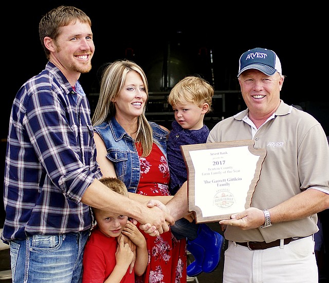 Garrett and Amanda Gittlein, with their sons, Mason, 6, and Colson, 3, received a plaque from Jim Singleton honoring them as the Benton County Farm Family of the Year for 2017 at their farm near Maysville on Tuesday, June 13. Singleton is the chairman of the Benton County Farm Family of the Year Selection Committee. 