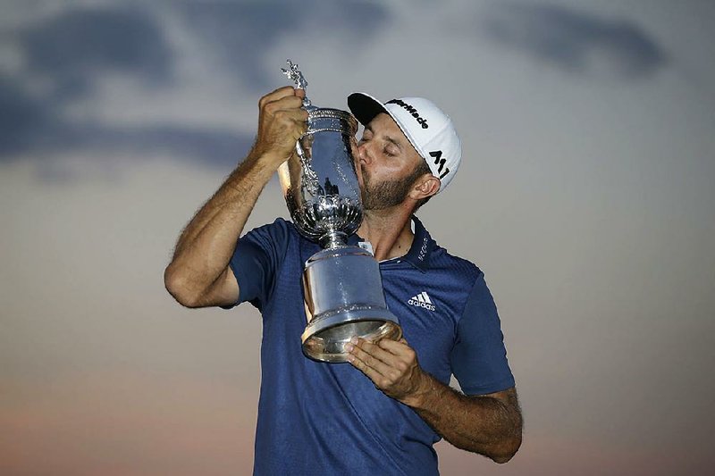 Dustin Johnson kisses the trophy after winning the U.S. Open golf championship last year.
