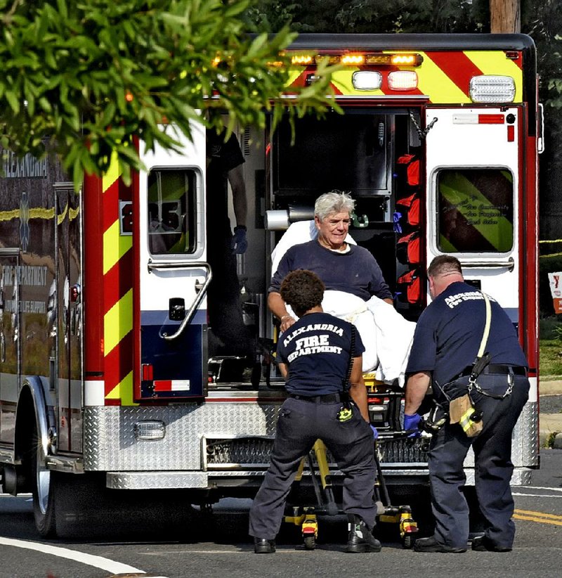 Emergency workers load Rep. Roger Williams of Texas into an ambulance Wednesday outside the baseball field in Alexandria, Va. Williams injured his ankle, and one of his aides was wounded.