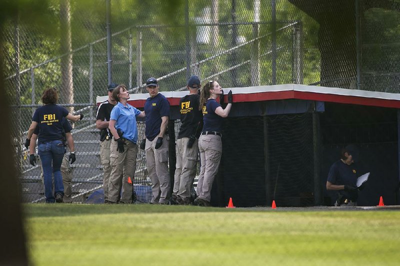 FBI personnel search around a dugout at the Eugene Simpson Stadium Park following the mass shooting in Alexandria, Va. A lone gunman who was reportedly distraught over President Donald Trump’s election opened fire at a baseball practice for congressional Republicans, injuring ÿve including Rep. Steve Scalise. The attacker died of his wounds.