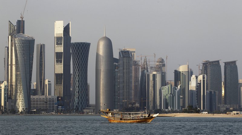 FILE - In this Thursday Jan. 6, 2011 file photo, a traditional dhow floats in the Corniche Bay of Doha, Qatar, with tall buildings of the financial district in the background. Qatar says it has pulled all of its troops from the border of Djibouti and Eritrea, East African nations that have a long-running territorial dispute which Doha had helped mediate. (AP Photo/Saurabh Das, File)