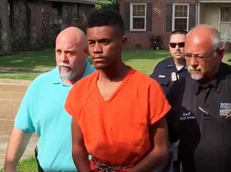 Officers escort Tyler Calamese, 18, into court Wednesday morning in Newport. He was ordered held without bail in the slaying of Newport police Lt. Patrick Weatherford.
