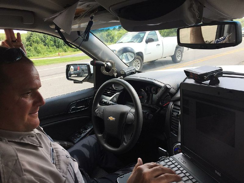 Arkansas Highway Police Cpl. Jason Daggs studies data while operating a virtual weigh station in Alma.