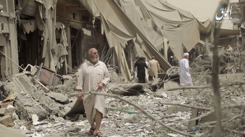FILE - This undated file frame grab from video posted online Monday, May 29, 2017, by the Aamaq News Agency, a media arm of the Islamic State group, shows people inspecting damage from airstrikes and artillery shelling in the northern Syrian city of Raqqa, the de facto capital of the IS. (Aamaq News Agency via AP, File)