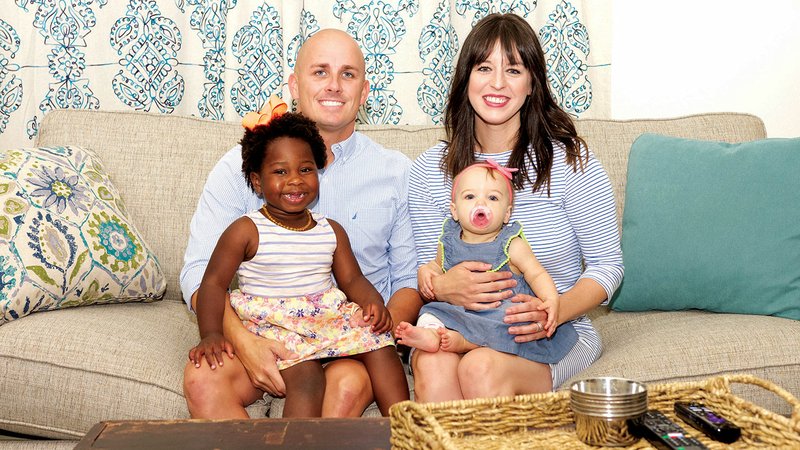 From left, Chris Massey sits on the couch holding daughter Stella, 3, beside his wife, Jennifer Massey, holding their 10-month-old daughter, Wallace. Chris said he tries to spend as much time at home with his family as he possibly can.