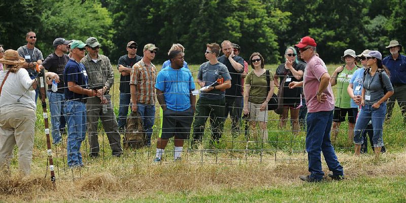 Ken Coffey, co-owner of a sheep and goat farm near Prairie Grove, talks about fencing Wednesday to military veterans participating in the Armed to Farm program. 