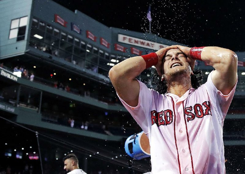 Boston Red Sox outfielder Andrew Benintendi (Arkansas Razorbacks) wipes Gatorade away from his face and hair after being doused in celebration earlier this week when his RBI single in the 12th inning gave the Red Sox a 4-3 victory over the Philadelphia Phillies. Benintendi went 3 for 5 with a walk, a double and two RBI in the game and is batting .348 (8 for 23) in his past 7 games.  