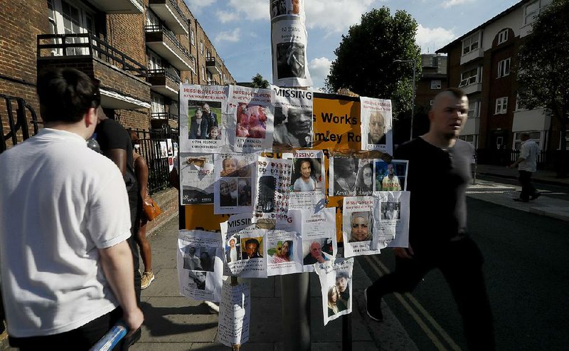 Posters of missing people cover a sign Saturday near the site of the Grenfell Tower fire in London.