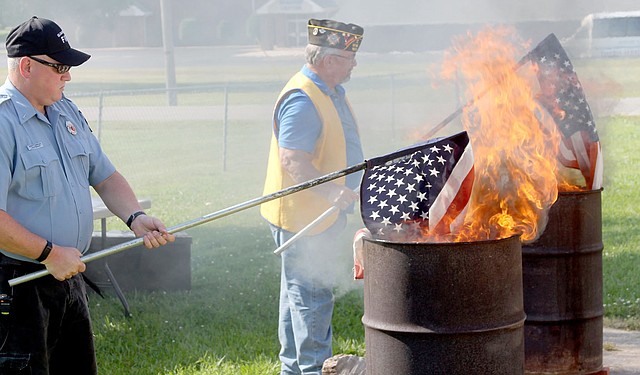 Michael Burchfiel/Siloam Sunday The Siloam Springs chapter of the Veterans of Foreign Wars hosted a flag retirement ceremony on Wednesday. The assembled veterans listened to a service and the reading of the U.S. flag retirement code. The VFW accepts flags that have to be taken out of service due to wear or damage at their location at 830 South Lincoln Street.