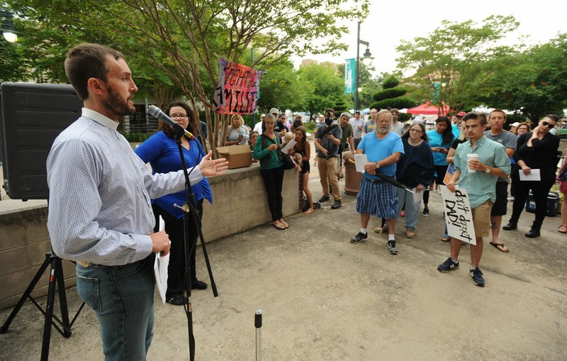 The Rev. Clint Schnekloth, founder and CEO of Canopy NWA and pastor of Good Shepherd Lutheran Church in Fayetteville, speaks Saturday during the rally.