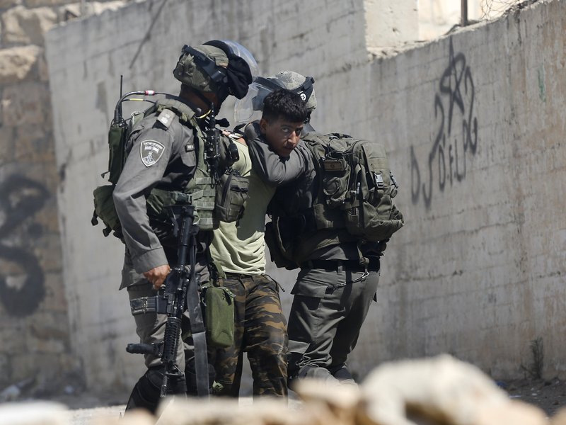 Israeli border police arrest a Palestinian during clashes in the West Bank village of Deir Abu Mash'al near Ramallah, Saturday, June 17, 2017. Israel security forces raided the village a day after an attack in Jerusalem killed a police officer. The three Palestinian attackers were from the village. 