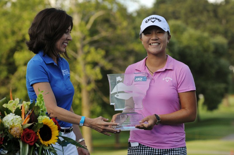 Gisel Ruiz (left) with Wal-Mart presents the champion's trophy to Lydia Ko of New Zealand on the 18th hole on Sunday June 26, 2016 during the final day of the LPGA Wal-Mart NW Arkansas Championship at Pinnacle Country Club in Rogers. Ko won with a tournament record score of 17 under par.