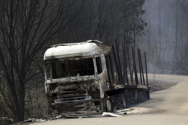 A burnt truck lies on a dirt road close to the road between Castanheira de Pera and Figueiro dos Vinhos, central Portugal, Sunday, June 18 2017. Raging forest fires in central Portugal killed at least 50 people, many of them trapped in their cars as flames swept over a road Saturday evening. (AP Photo/Armando Franca)