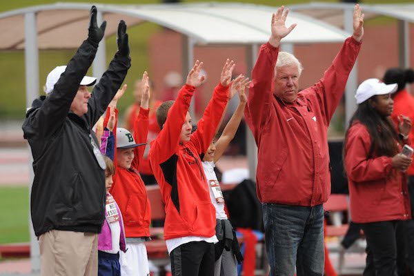 Arkansas coaches Chris Bucknam (left) and Lance Harter call the Hogs Saturday, April 22, 2017, with winners of the Fastest Kid in Fayetteville competition during the John McDonnell Invitational at John McDonnell Field in Fayetteville.