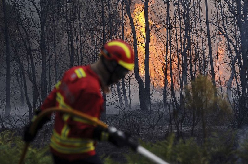 Portuguese firefighters work to stop a forest fire from reaching the town of Figueiro dos Vinhos on Sunday in central Portugal.