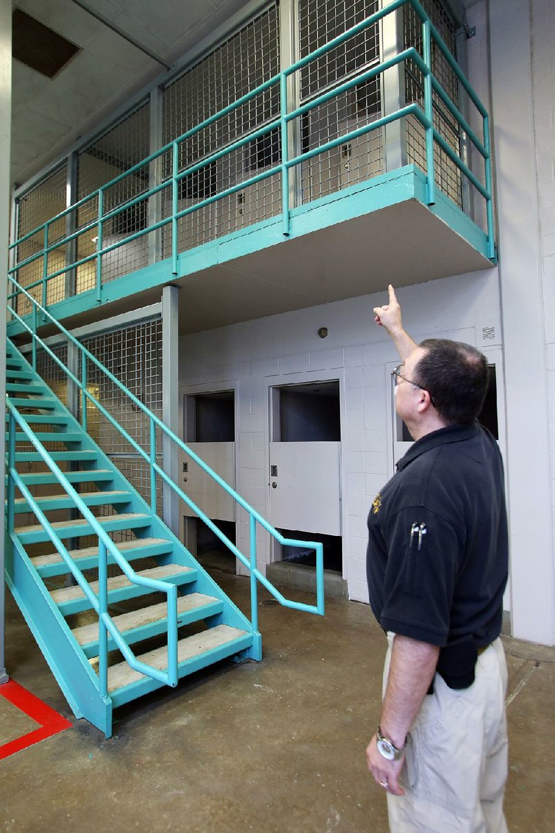 Pulaski County jail supervisor Lt. Rodney Sheperd shows where an inmate fell over the second-floor railing, prompting the installation of fencing to prevent another accident.