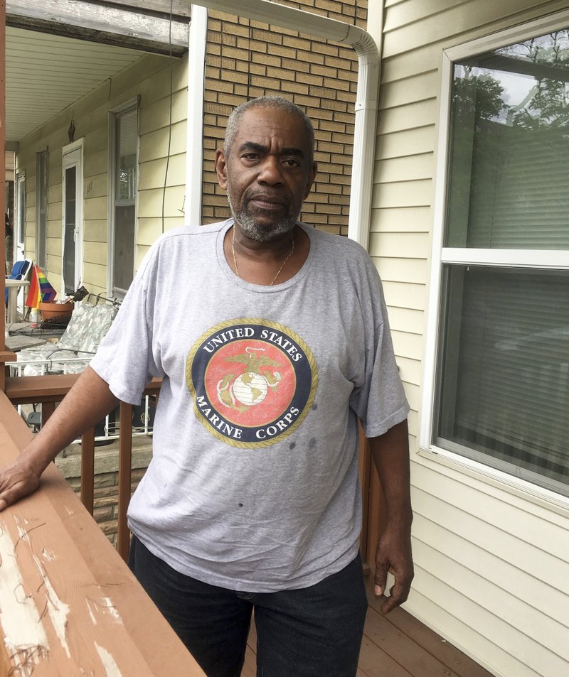 In a June 15, 2017 photo, Kevin Fantroy, 62, stands on his porch in Hamtramck, Mich. He and dozens of other black residents are challenging higher property tax bills. They say the higher taxes violate a settlement in a decades-old lawsuit over housing discrimination against blacks.