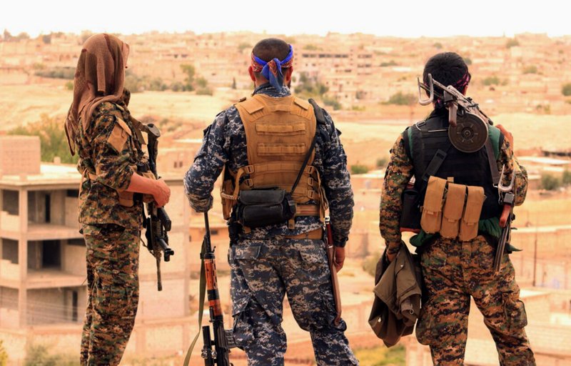 FILE - This April 30, 2017, file photo provided by the Syrian Democratic Forces (SDF) shows fighters from the SDF looking toward the northern town of Tabqa, Syria. The U.S.-led coalition headquarters in Iraq said in a written statement that a U.S. F-18 Super Hornet shot down a Syrian government SU-22 on Sunday, June 18, after it dropped bombs near the U.S. partner forces, known as the Syrian Democratic Forces. The shootdown was near the Syrian town of Tabqa. 