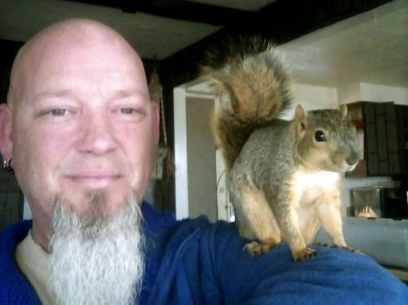 This undated photo provided by Adam Pearl shows Pearl with his pet squirrel Joey in Meridian, Idaho. 