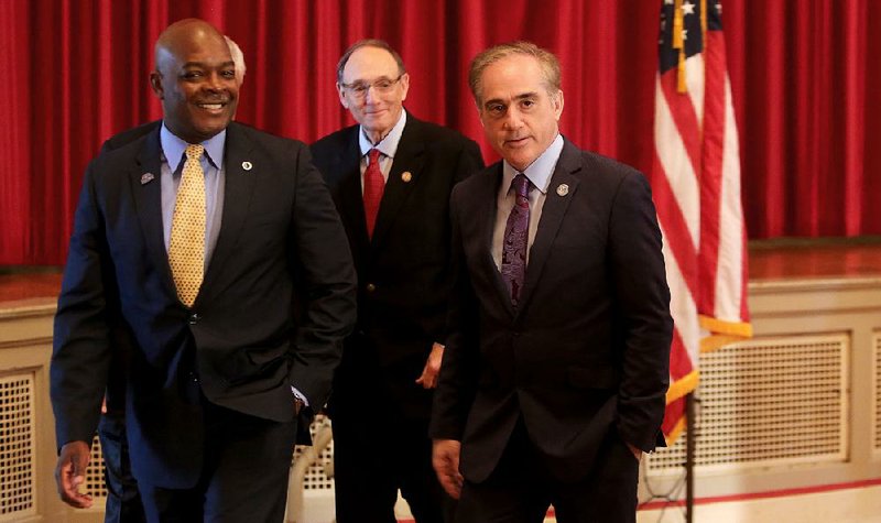 Bryan Matthews (left), medical center director at Veterans Health Care System of the Ozarks, and U.S. Rep. Phil Roe (R-Tenn.), chairman of the House Veterans Affairs Committee, walk with Veterans Affairs Secretary David Shulkin (right), on Monday after a news conference on the VA campus in Fayetteville.