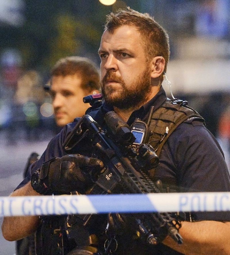 Police officers in London’s Finsbury Park guard the cordoned area where a vehicle plowed into pedestrians earlier Monday.