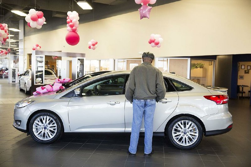 A potential buyer looks at a 2016 Ford Focus in the Sutton Ford dealership in Matteson, Ill., in this file photo. Ford has canceled plans to build the Focus in Mexico and will begin importing the model from China next year. 