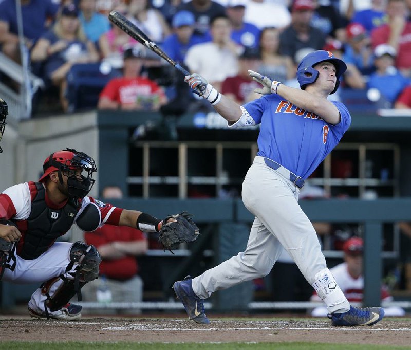 Florida’s Deacon Liput hit a three-run home run in the fourth inning Tuesday that served as the catalyst in the Gators’ 5-1 victory over Louisville at the College World Series in Omaha, Neb.