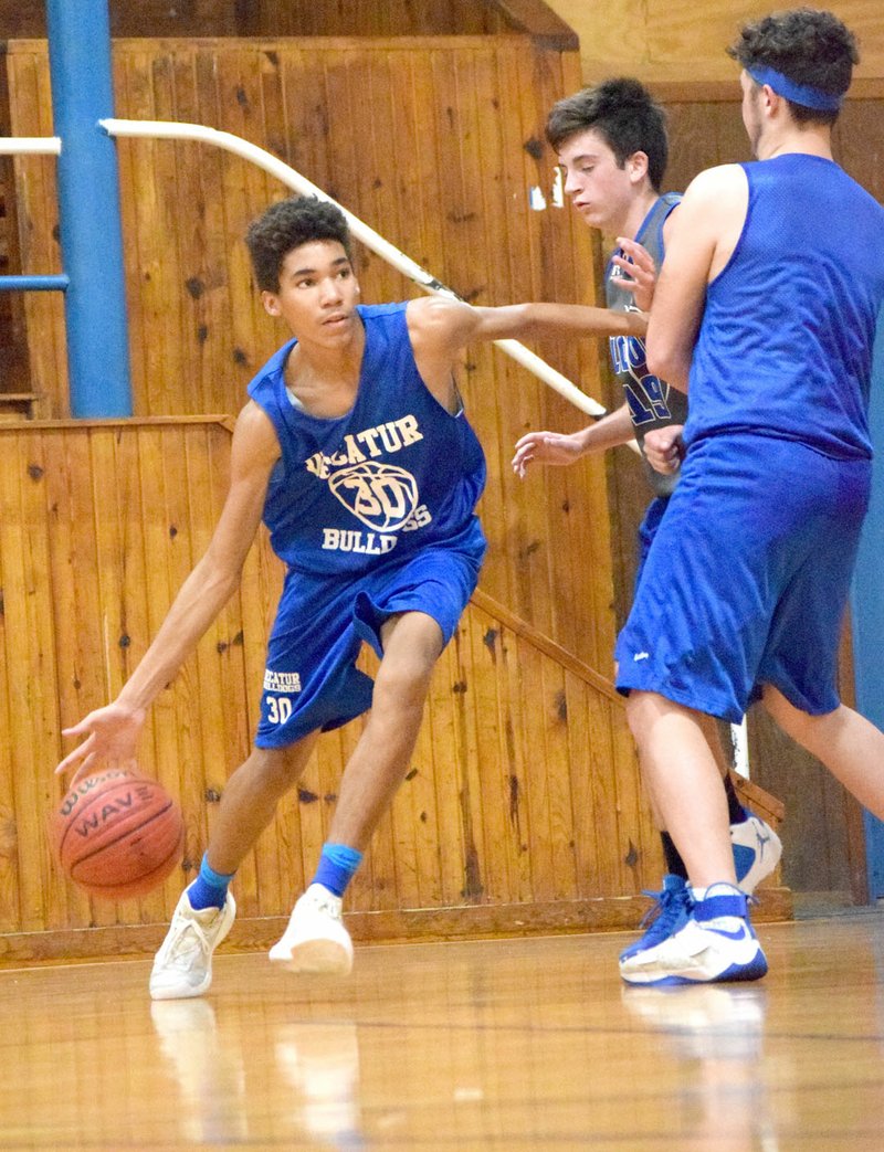 Photo by Mike Eckels With a block by teammate Levi Newman (right), Decatur&#8217;s Tafari James (30) slipped around a Colcord player driving down court toward the Bulldogs&#8217; basket. Decatur traveled to Colcord June 13 to play in the second week of the Colcord High School Summer Basketball League at the old gym in Colcord, Okla.