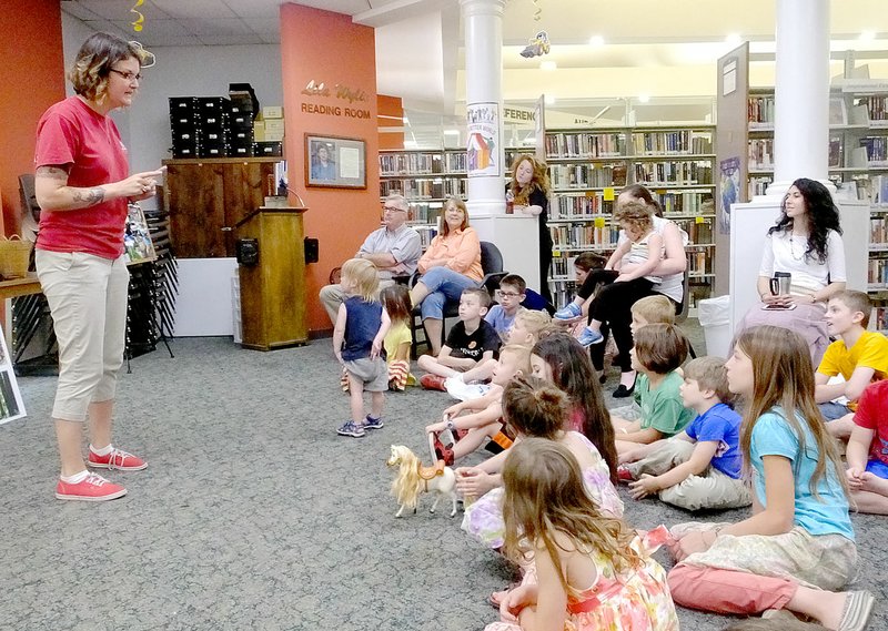 Lynn Atkins/The Weekly Vista Sarah Benson, the manager of the Museum of Native American History in Bentonville, spoke about Alaska to participants in the library Summer Reading Program on Thursday.