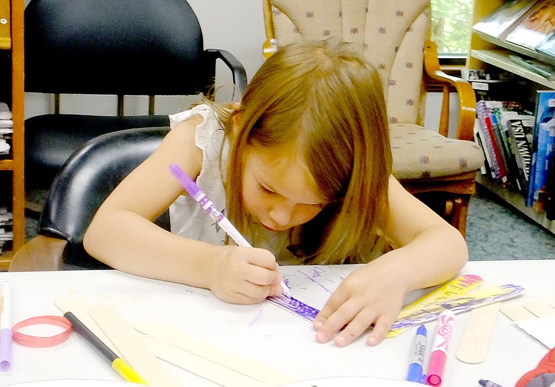 Lynn Atkins/The Weekly Vista Luella Rippy concentrates on her coloring as she creates a Father&#8217;s Day gift during the library&#8217;s weekly Storytime on Friday morning.