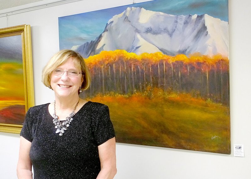 Lynn Atkins/The Weekly Vista Patty Halley stands in front of her landscape which shows the view from her former front window. Halley moved to Bella Vista from Alaska and was featured in Wishing Spring&#8217;s first exhibition last weekend.