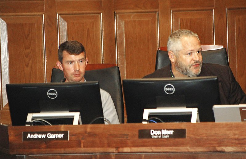 NWA Democrat-Gazette/STACY RYBURN City Planning Director Andrew Garner (left) and Chief of Staff Don Marr listen Tuesday during a Fayetteville City Council meeting. The council approved changing the industrial zoning districts in the city to include shopping uses.