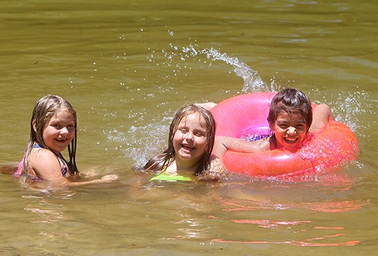 The Sentinel-Record/Richard Rasmussen SPLASHING AROUND: From left, 6-year-old twins Riley and Linsey Ledbetter swim with their friend, Hiiaka Silva, 7, at Hill Wheatley Park on Tuesday. The three, all of Hot Springs, were visiting the park with other family members.