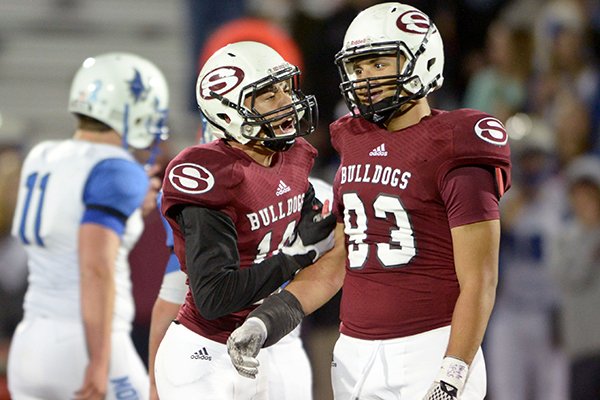 Jayden Minchew (10) and Isaiah Nichols (93), Springdale defenders, celebrate after Nichols helped make a stop against Rogers on Friday Nov. 6, 2015 during the first quarter of the game in Springdale's Jarrell Williams Bulldog Stadium.
