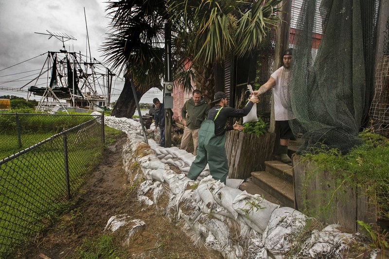 Workmen with the city and volunteers help to shore up gaps in the levee in Lafitte, La. as Tropical Storm Cindy threatens the Louisiana coast, Tuesday, June 20, 2017. 