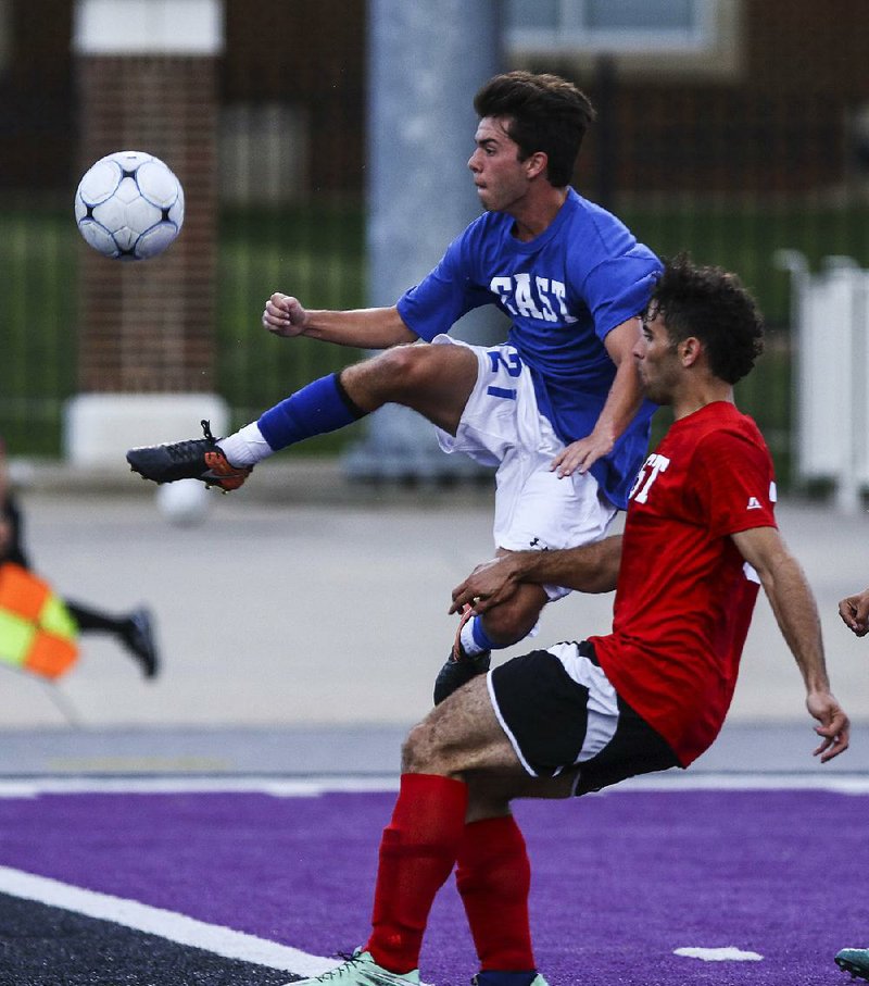 Nathan Simons of Jonesboro (left) gets to the ball before a West defender can cut him off in Wednesday’s all-star boys soccer game at Estes Stadium in Conway. Simons was named the East team’s outstanding player, but the West pulled out a 3-2 victory.