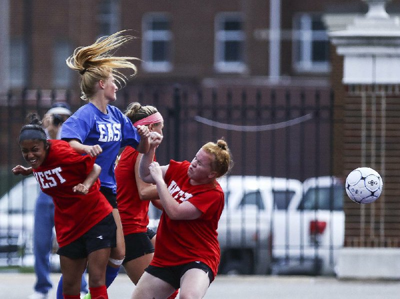 Players collide after chasing down a loose ball during the Arkansas High School Coaches Association All-Star girls soccer game Wednesday at Estes Stadium in Conway. The East, behind two goals from University of Arkansas, Fayetteville signee Caroline Campbell, beat the West 3-1.