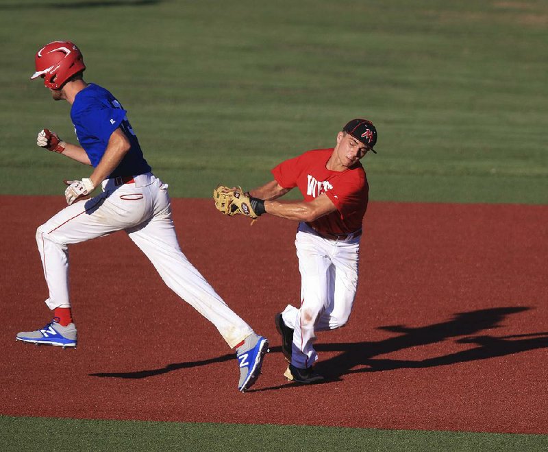 West infielder Shaeffer Loyd (right) tags East base runner Bradley Chalk for an out during Tuesday’s all-star baseball game at Bear Stadium in Conway. The teams tied 10-10 in the first game before the East pulled away for a 9-6 victory in Game 2.