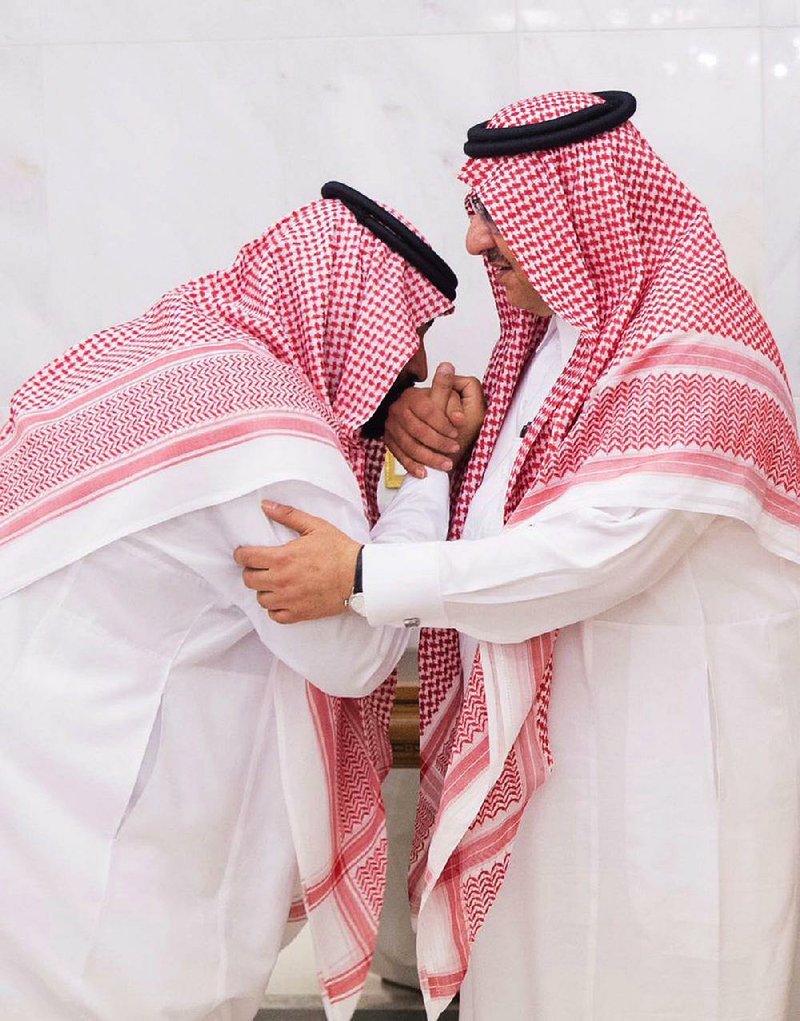 Mohammed bin Salman (left), newly appointed as crown prince, kisses the hand of Prince Mohammed bin Nayef at the royal palace Wednesday in Mecca, Saudi Arabia.