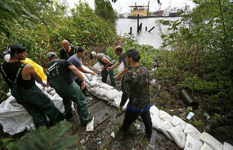 Volunteers stack sandbags Wednesday near the Mississippi River in Lafitte, La., in preparation for expected !ooding caused by heavy rain from Tropical Storm Cindy.