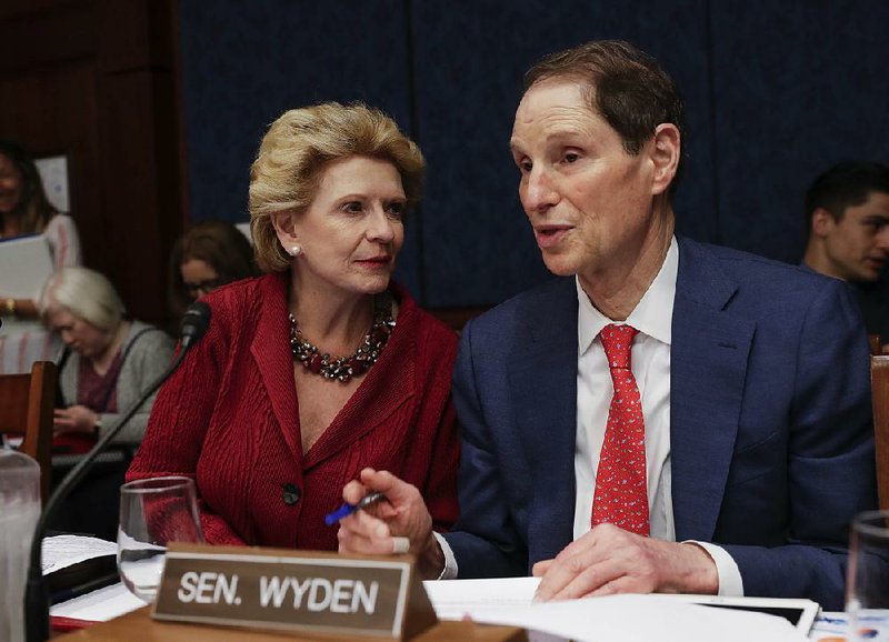 Sen. Debbie Stabenow of Michigan confers with fellow Democratic Sen. Ron Wyden of Oregon at a hearing Wednesday by the Democratic Policy and Communications Committee to draw attention to how the Senate GOP health care bill could affect rural communities.