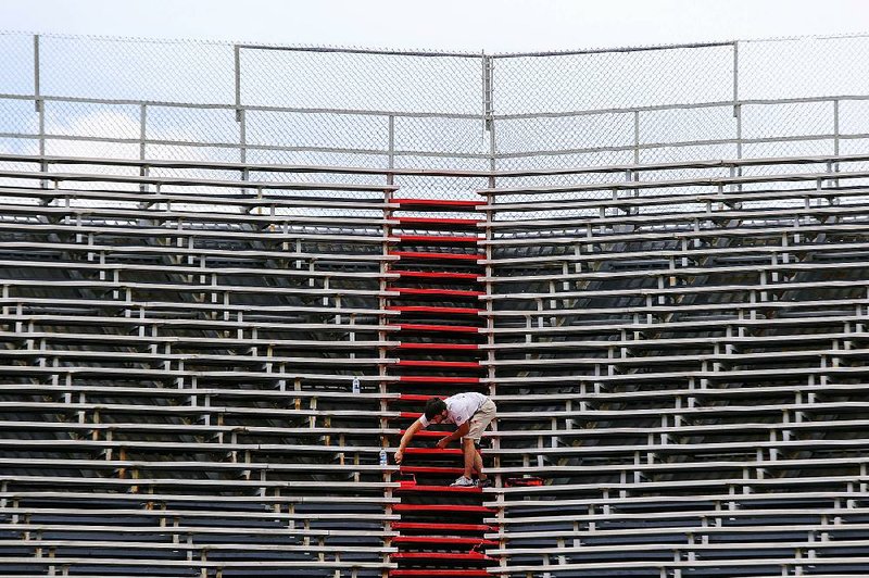 Arkansas Democrat-Gazette/MITCHELL PE MASILUN --6/21/2017--
Park Specialist Michael Flake puts a fresh coat of paint on the bleachers at War Memorial Stadium in Little Rock Wednesday, June 21, 2017. 