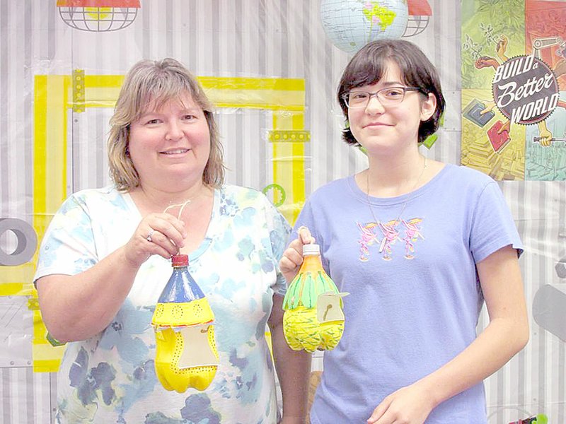 Photo submitted LeaAnn Bunting and her daughter, Sophie Jaquez, show off the bird feeders they created during a recent class hosted by the McDonald County Library.