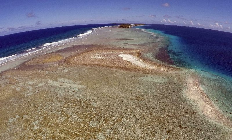 A small uninhabited island on Majuro Atoll in the Marshall Islands that has slipped beneath the water line, only showing a small pile of rocks at low tide, is seen in this aerial photo from Nov. 5, 2015.