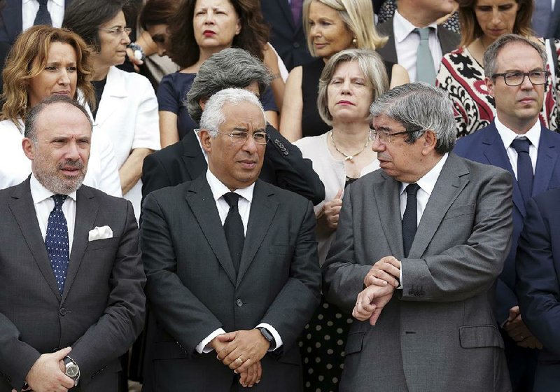 Portuguese Prime Minister Antonio Costa (center) and Parliament President Eduardo Ferro Rodrigues (right) stand with members of the government and lawmakers on the steps of the Parliament building in Lisbon on Wednesday waiting to observe a minute of silence in memory of the victims of a wildfire.