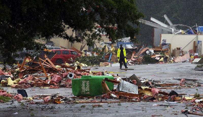 A police officer stands guard after a possible tornado touched down, destroying several businesses Thursday in Fairfield, Ala. 