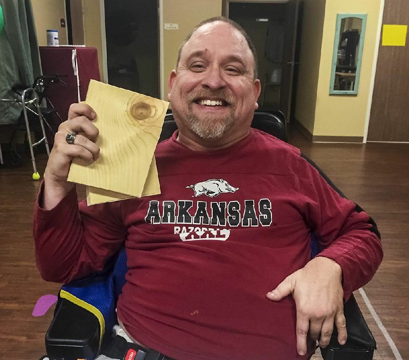 Jason Sasser proudly displays a board he broke while training with tae kwon do instructor Holly Hardin of Memphis in December. “I just remember crying my head off because I never in a million years thought that I would be able to do something like that,” Sasser said.